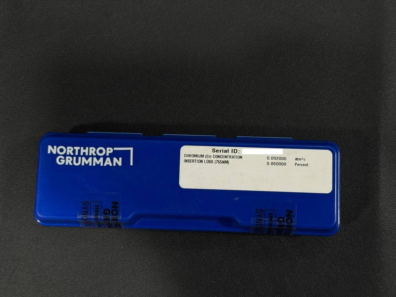 Blue Northrop Grumman component on a black background
